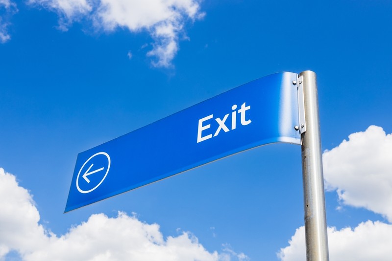 Blue Exit Sign Against Blue Sky